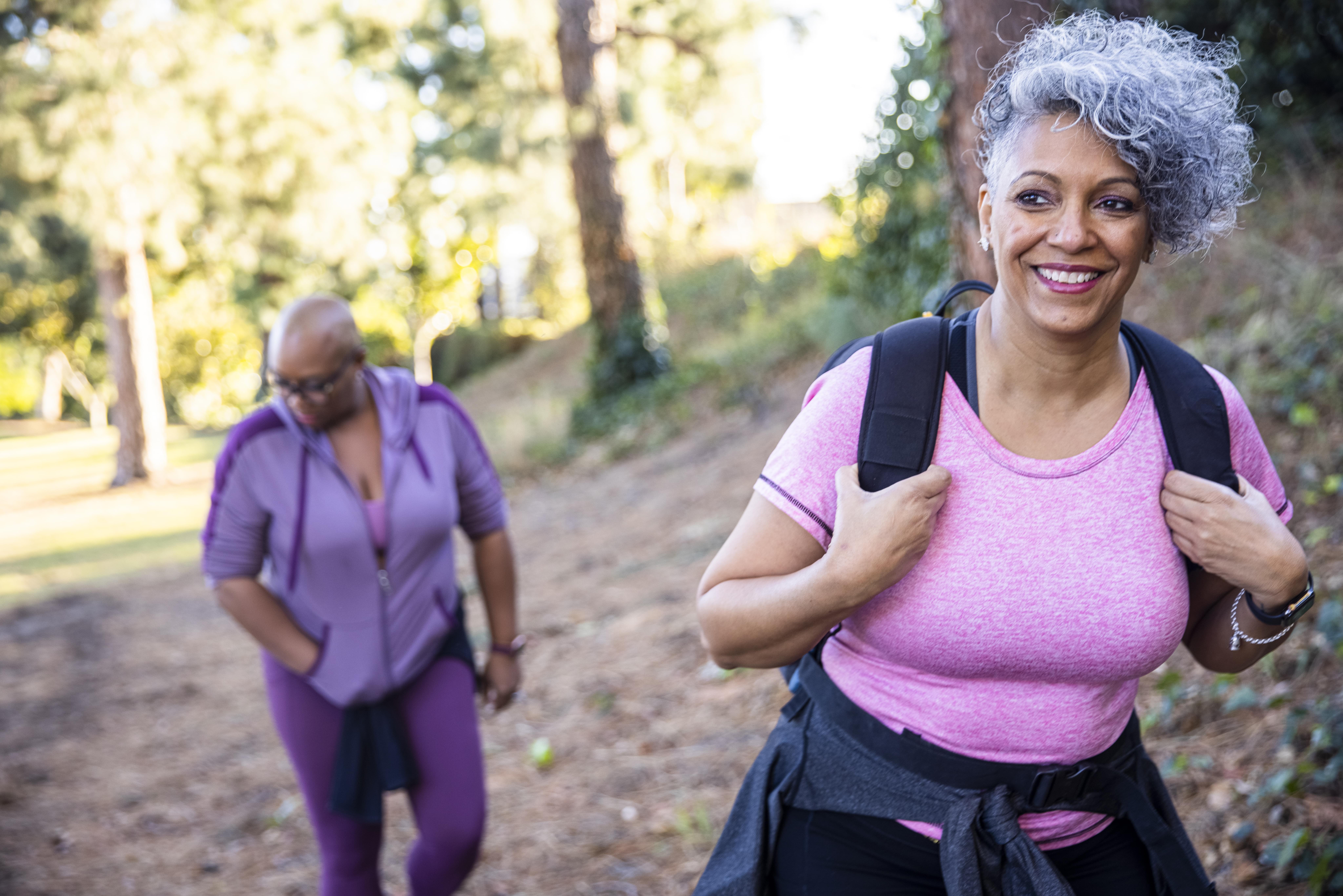 A senior black woman hiking in nature.