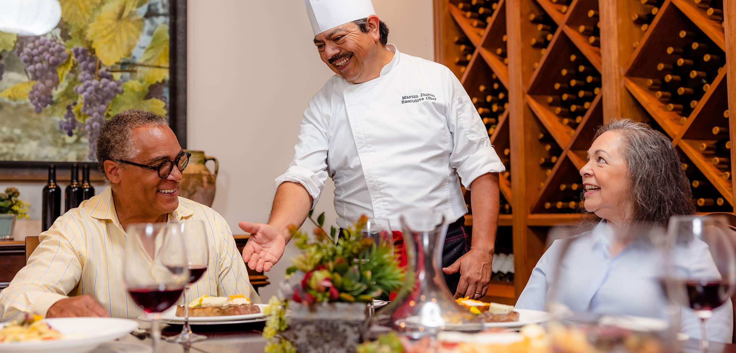 A chef talking to diners in the wine room