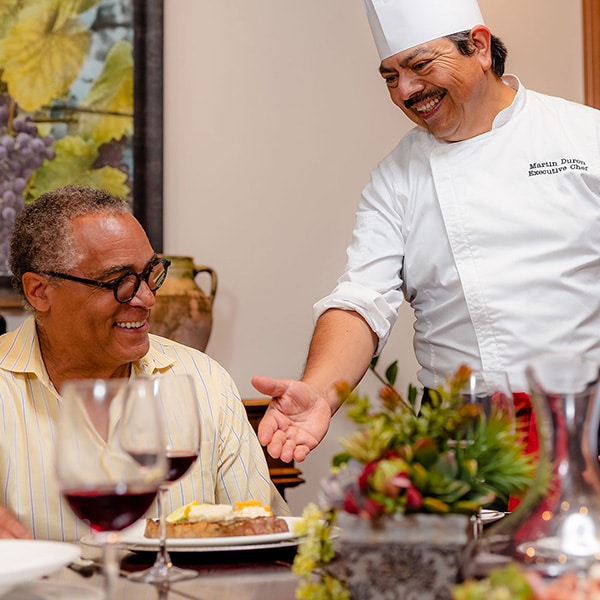 A chef giving people food at a restaurant at Stoneridge Creek