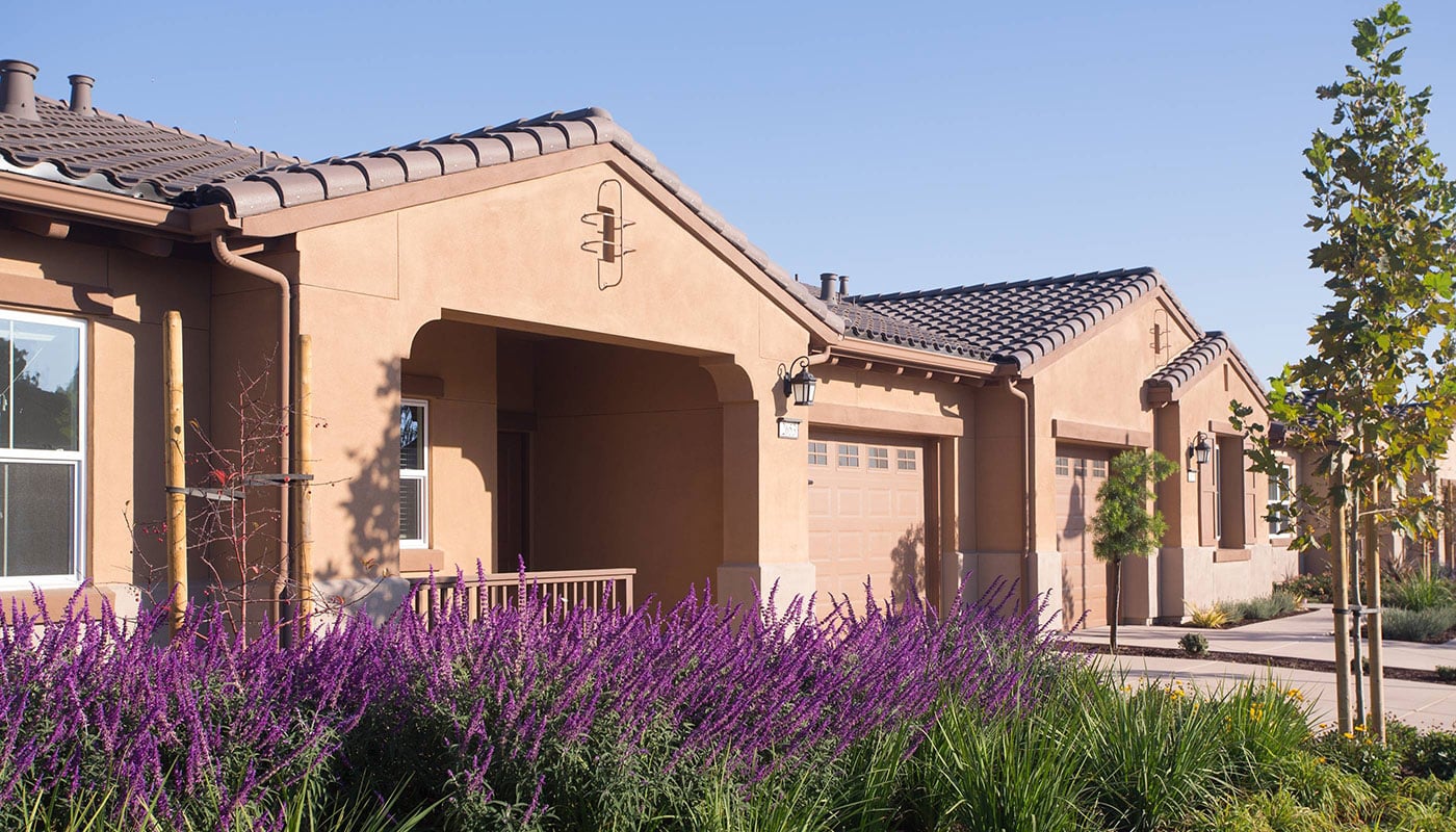 Front of a villa home with purple flowers at Stoneridge Creek
